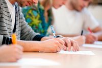 étudiants écrivant sur une table Pourquoi apprendre des langues étrangères est-il vital de nos jours ?