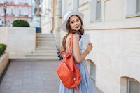une étudiante qui se promène dans la rue étudiante, sourire, cahier, rue